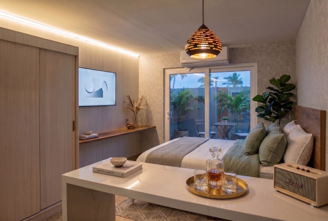 Interior of a finished Casabella suite — white walls, tiled floor and glass doors opening onto a private backyard.