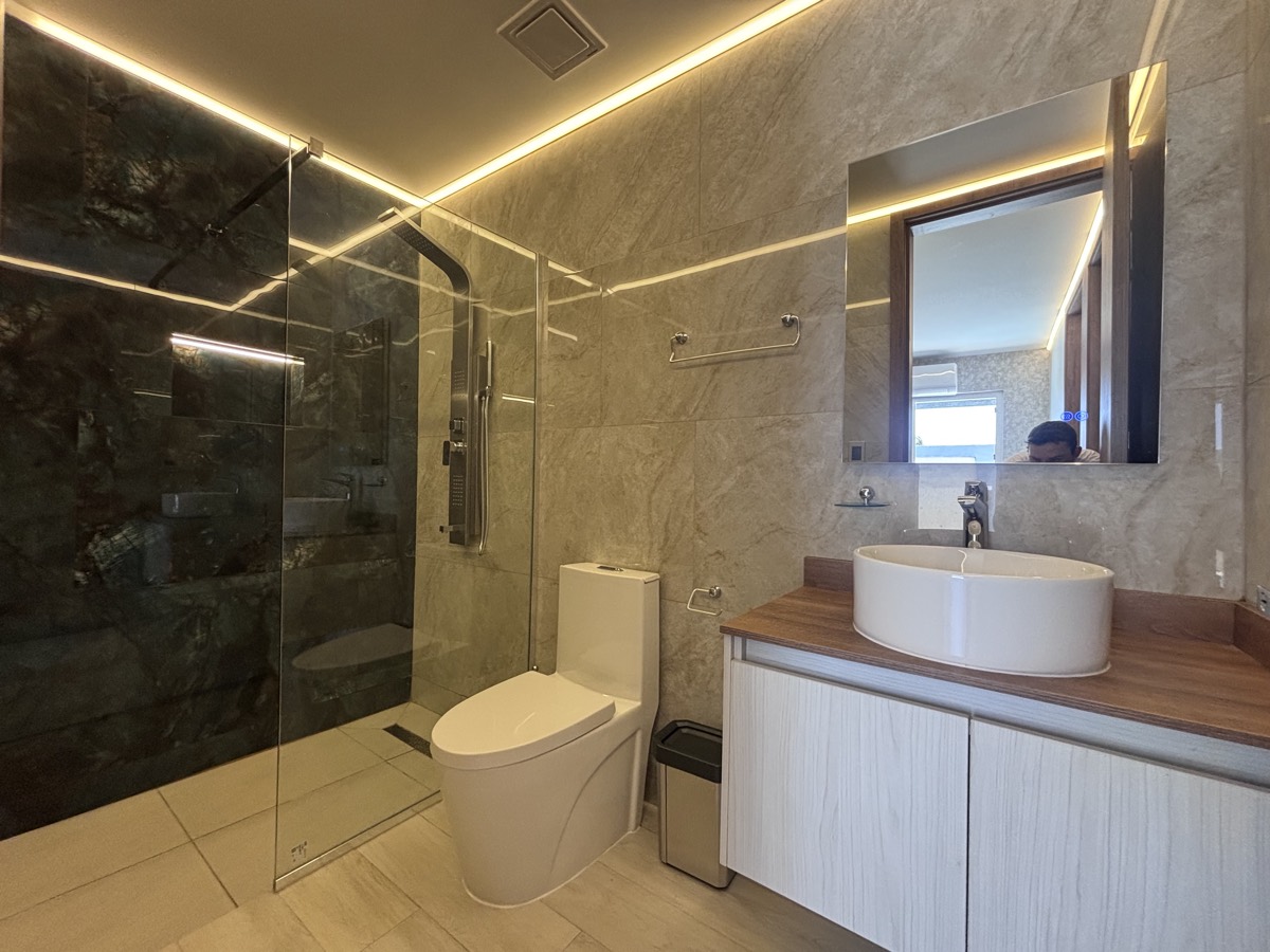 A bathroom in a Casabella suite — dark stone walls, a glass shower and a stone vanity.
