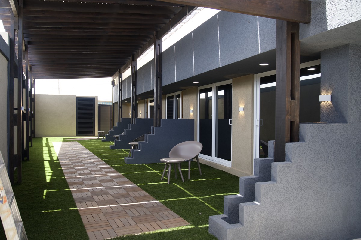 Suite doors opening onto turf and the shaded walkway at Casabella Suites.